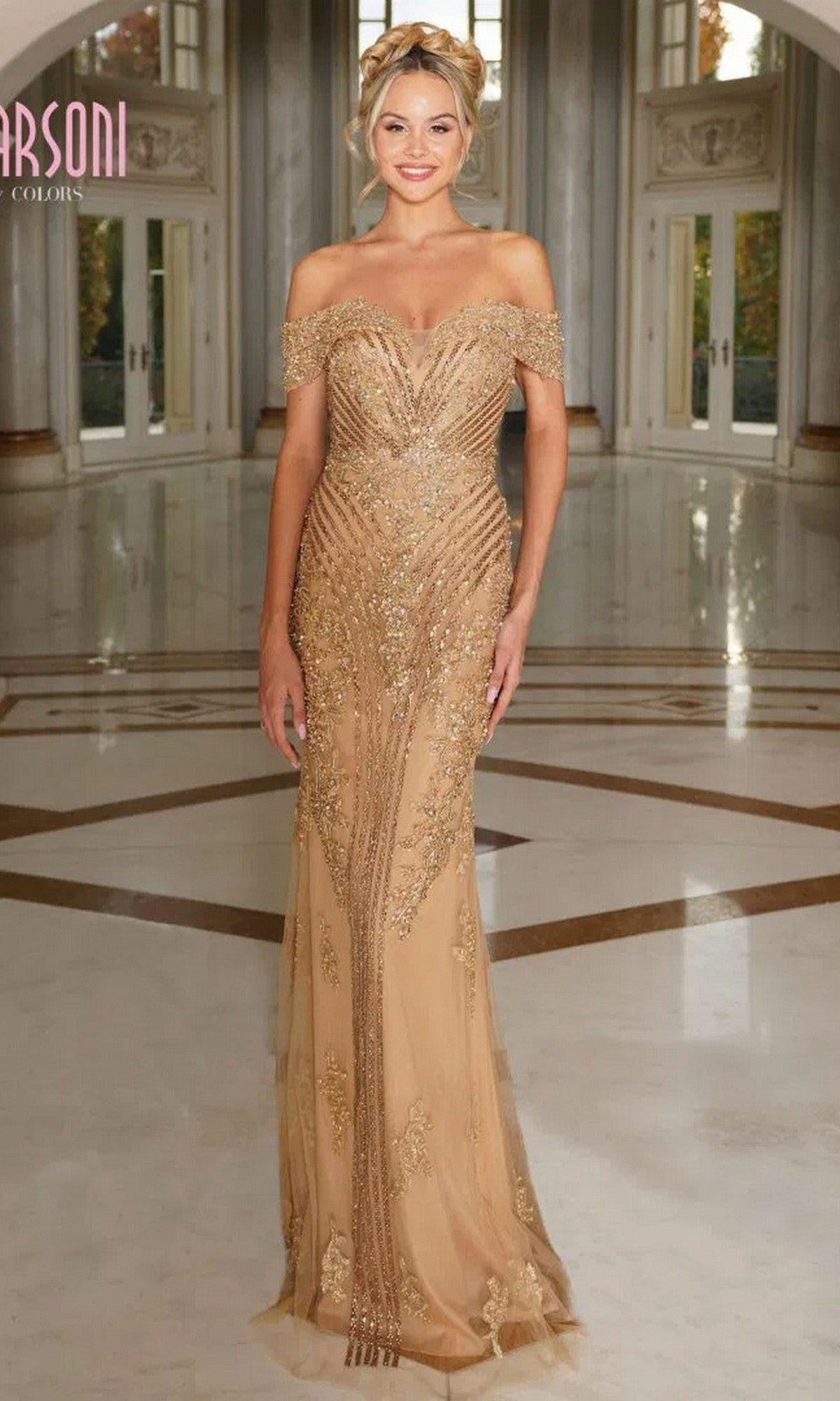 A woman poses indoors on a polished marble floor wearing the Marsoni MV1275 long formal dress in gold, featuring an off-the-shoulder neckline and beaded embellishments.